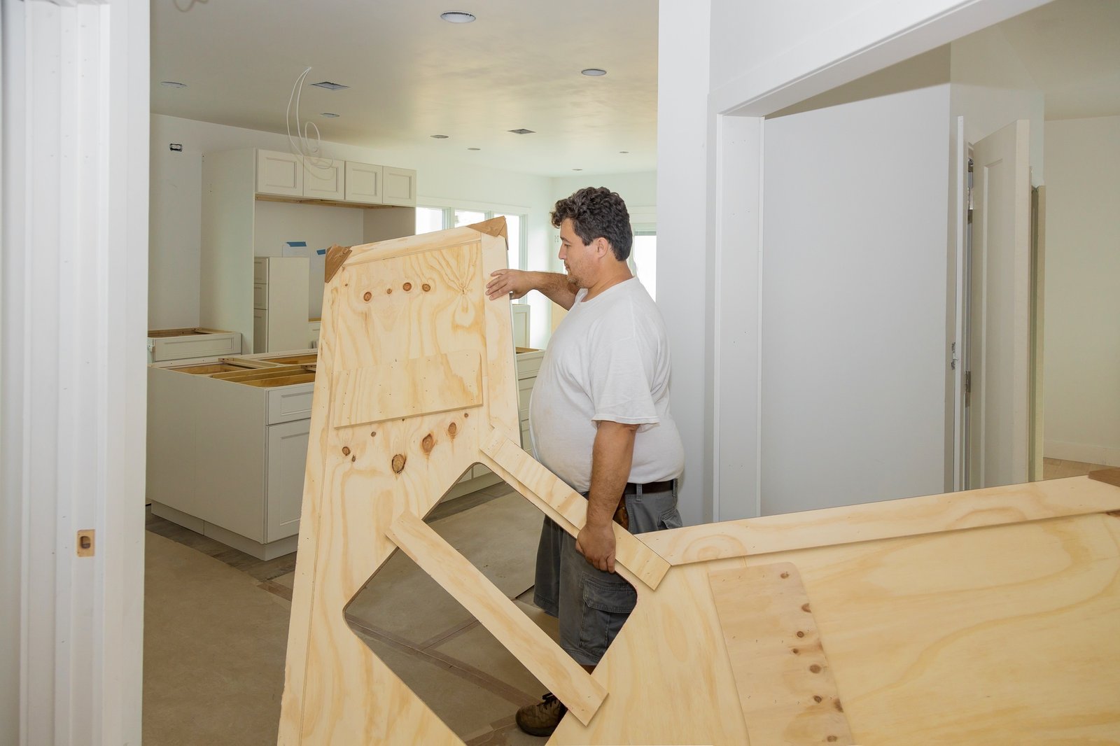 Carpenter installing c counter top in a kitchen remodel.